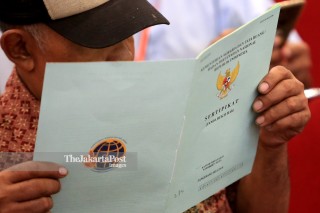 resident of South Tangerang and Tangerang Regency reads his newly distributed land certificate at ICE BSD