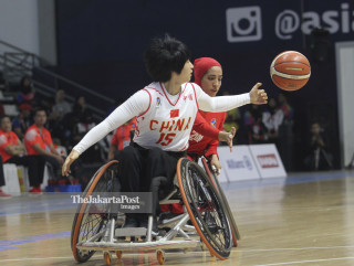 Pebasket Cina Xiolian Huang (depan) berhasil melewati penjagaan pemain Iran