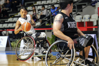 Pemain bola basket kursi roda Chinese Taipei berusaha mengoper bola melewati pemain Korea Selatan