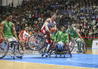 Pemain bola basket kursi roda putra Indonesia Donald Putra Santoso (ketiga kiri) berusaha melewati penjagaan pemain Iraq Issa Al-Yasiri (5) untuk memasukan bola ke keranjang dalam pertandingan bola basket kursi roda di Asian Para Games 2018 di Basketball H