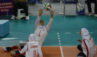- pemain Iran memberi umpan kepada rekan setim dalam final bola voli duduk melawan China