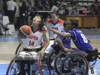 Pemain basket kursi roda Jepang Chinami Shimizu (kiri) berusaha melakukan layup ke keranjang Thailand