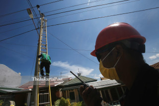 Petugas PLN mengganti tiang listrik yang roboh akibat gempa dan tsunami di depan pusat perbelanjaan Palu Grand Mall Sulawesi Tengah