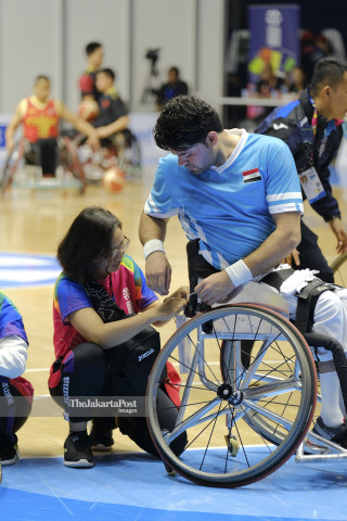 Relawan membantu atlet memasang nomor di Basket Hall GBK.