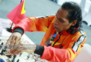 Atlit catur Timor Leste Martins Do Rego mengangkat  bidak catur  saat bertanding di babak penyisihan catur cepat  ke lima di ajang Asian Para Games 2018, di Jakarta, Jumat (12/10/2018). INAPGOC/Setiyo Sc