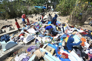 Warga memilih pakaian bekas di area pemakanan dekat dengan Posko Pengungsian Perumnas Balaroa, Palu, Sulawesi Tengah