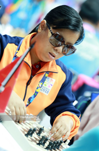 Atlit catur Myanmar Htwe Ohnmar  mengangkat  bidak catur  saat bertanding di babak penyisihan catur cepat  ke lima di ajang Asian Para Games 2018, di Jakarta, Jumat (12/10/2018). INAPGOC/Setiyo Sc