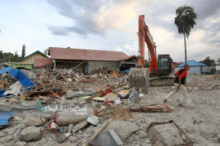 Alat berat membersihkan puing gempa dan tsunami di pantai Talise Palu, Sulawesi Tengah
