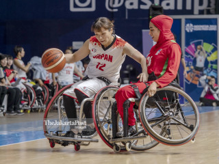Pemain bola basket kursi roda wanita asal Jepang Ikumi Fujii (kiri) berusaha membawa bola melewati pemain Iran Somayeh Kohzadpour dalam pertandingan bola basket kursi roda pada Asian Para Games 2018 di Basketball Hall Gelora Bung Karno, Jakarta