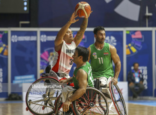 Pemain bola basket kursi roda Indonesia Daryoko (kanan) dihadang dua pebasket Iraq Al-Baidhani Alaadan Abdullah Alaa dalam pertandingan bola basket kursi roda putra pada Asian Para Games 2018 di Basketball Hall Gelora Bung Karno, Senayan, Jakarta