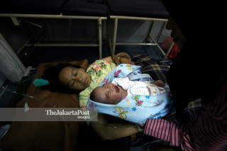 Seorang perawat menunjukkan bayi yang baru dilahirkan di KRI dr Soeharso-990 yang bersandar di Dermaga Port Of Pantoloan, Palu, Sulawesi Tengah