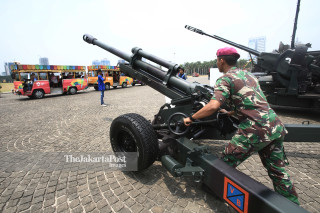 Seorang prajurit TNI Marinir mempersiapkan Howitzer 105 MM saat dipamerkan bersama alat utama sistem persenjataan (Autsista) TNI lainnya di Monumen Nasional (Monas), Jakarta Pusat