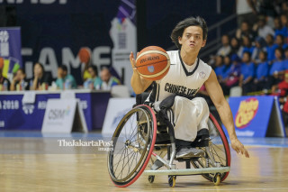 Pemain bola basket kursi roda Chinese Taipei Kao Chen Yi-chen membawa bola.