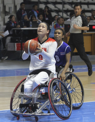 Pemain bola basket kursi roda putri Jepang Momoko Suzuki bersiap melakukan tembakan ke keranjang tim Thailand